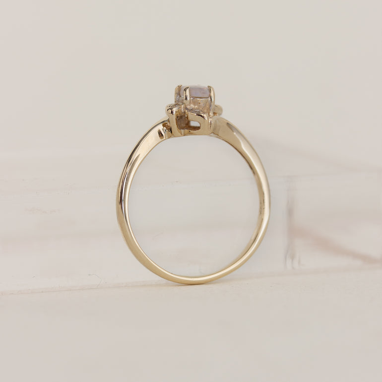 Gold ring with a diamond on a light beige background