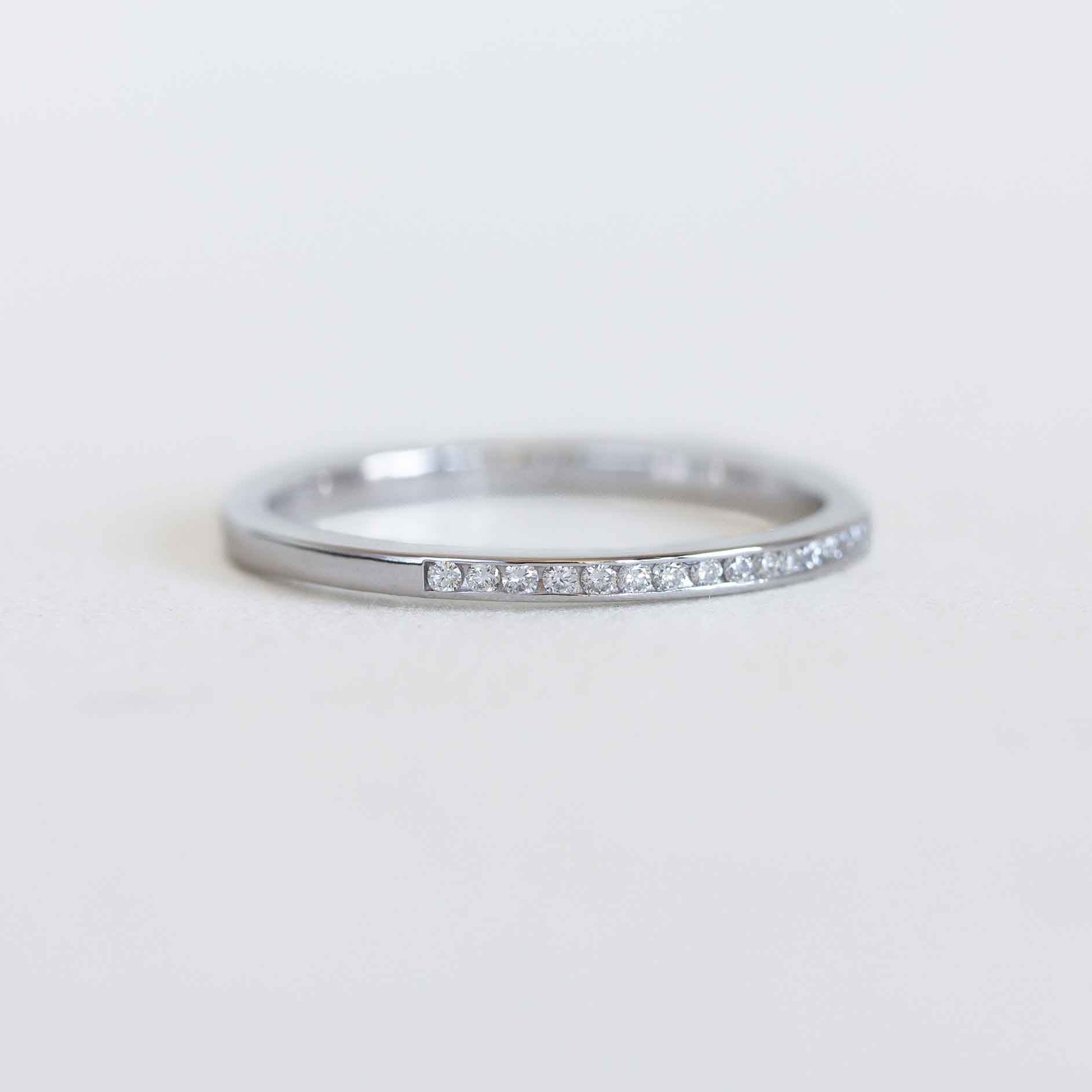 White gold ring with diamonds on a light gray background