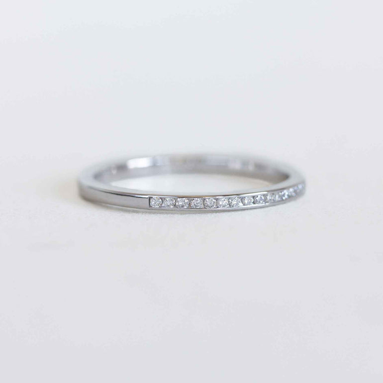 White gold ring with diamonds on a light gray background
