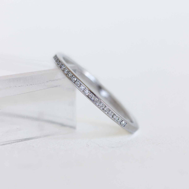 White gold ring with diamonds on a light gray background