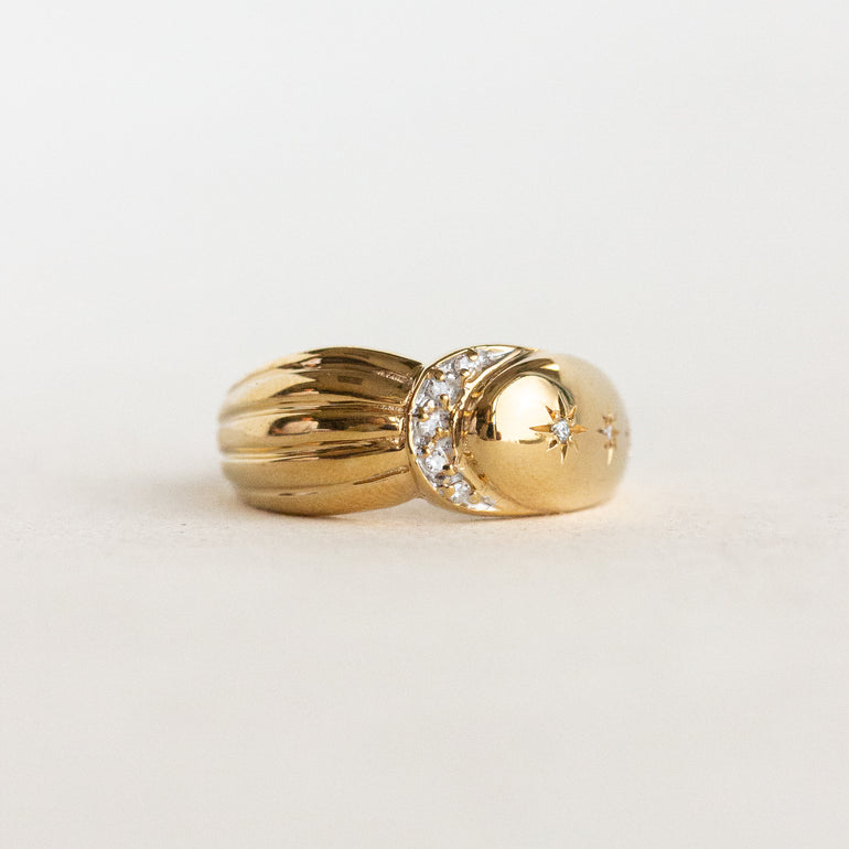 Two gold rings with diamond accents on a light gray background