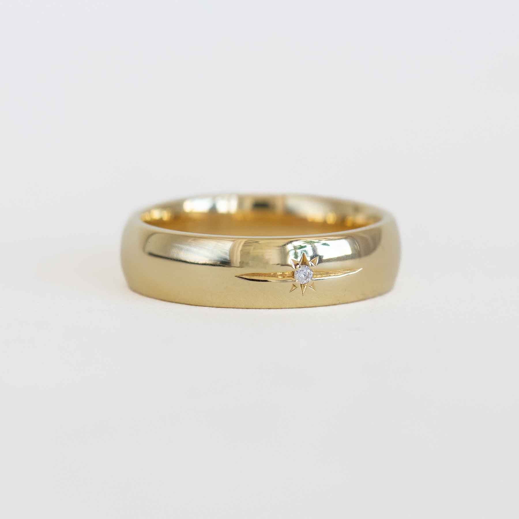 Gold ring with a diamond on a light gray background
