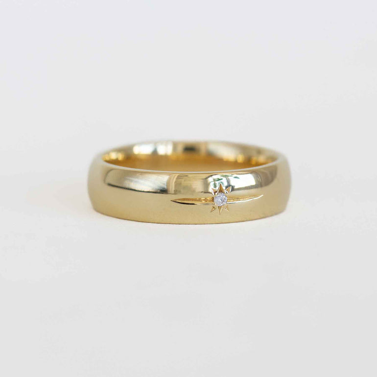 Gold ring with a diamond on a light gray background