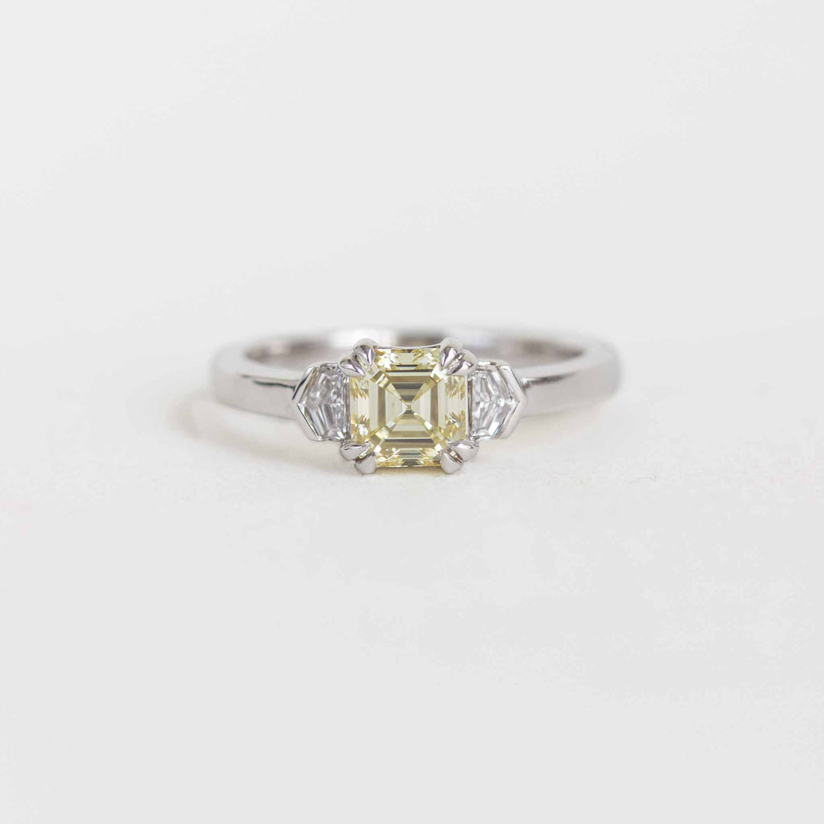 A yellow emerald-cut diamond engagement ring in a silver-toned setting with accent diamonds, shown on a light gray background with a 'Ready-to-Ship' label below.