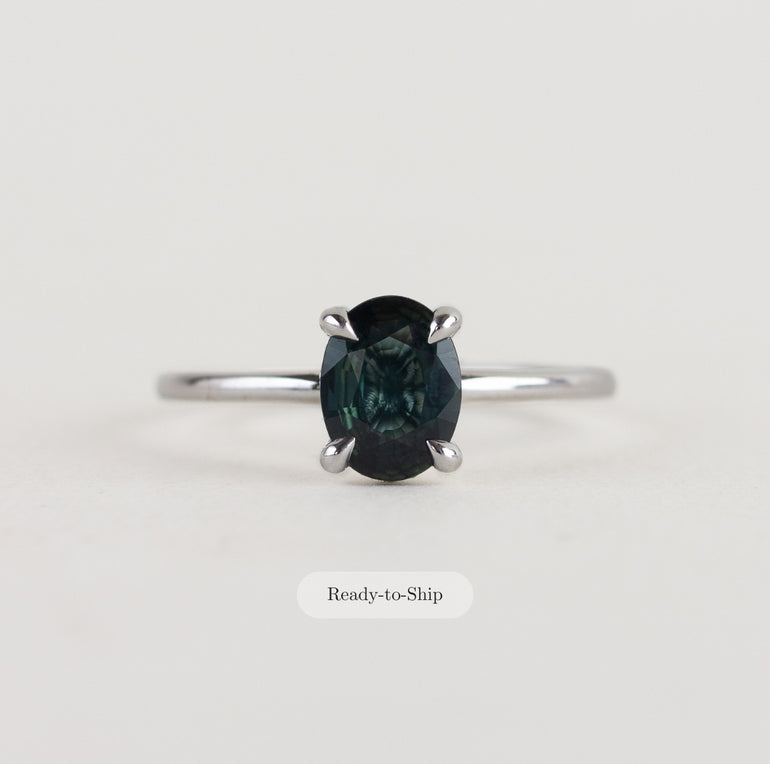 14K white gold ring with a moody dark teal sapphire