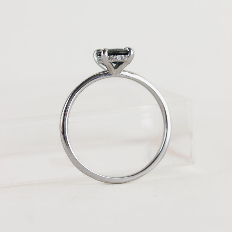 14K white gold ring with a moody dark teal sapphire