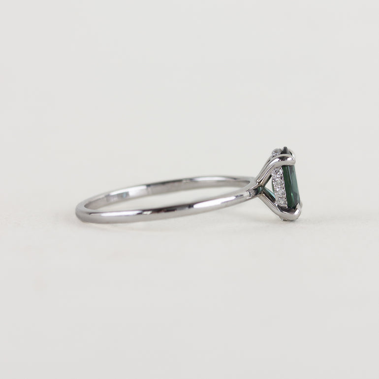 14K white gold ring with a moody dark teal sapphire