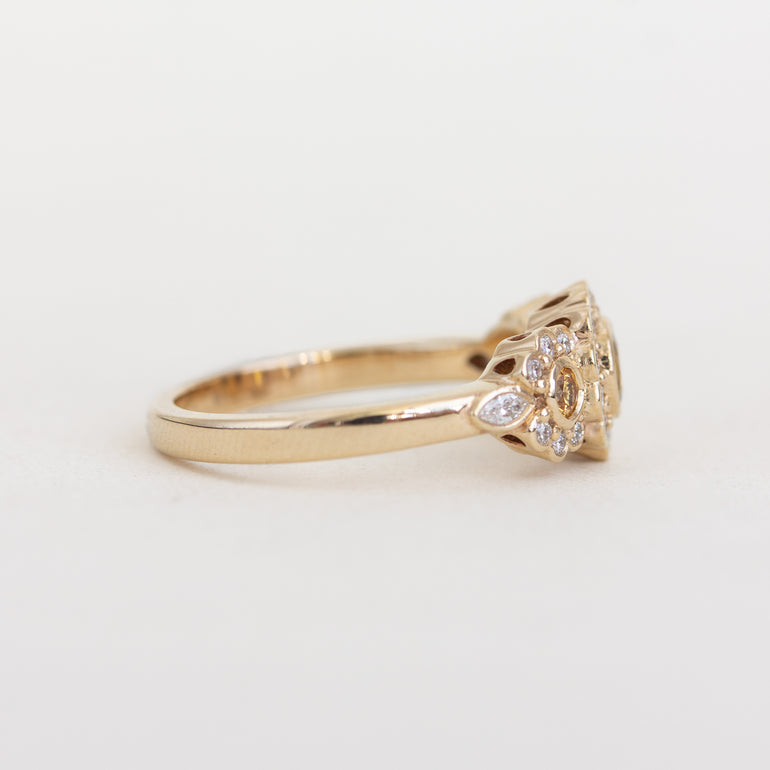 Gold ring with a diamond on a light gray background
