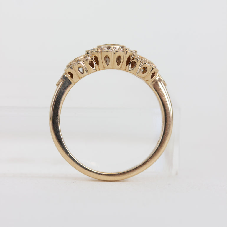 Gold ring with intricate design on a white background