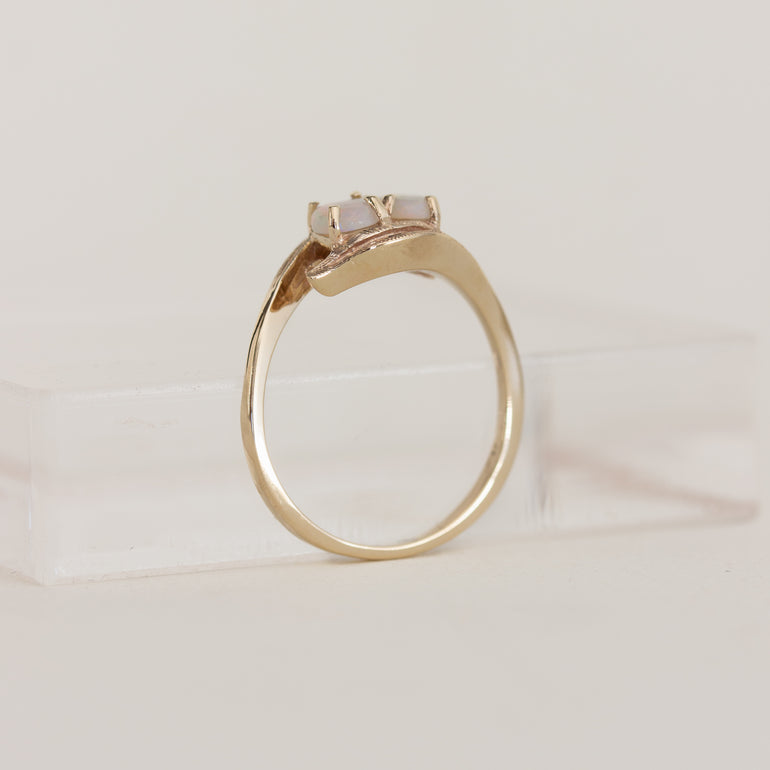 Gold ring with a central gemstone on a light beige background