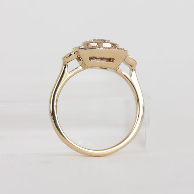 Gold ring with a diamond on a light gray background