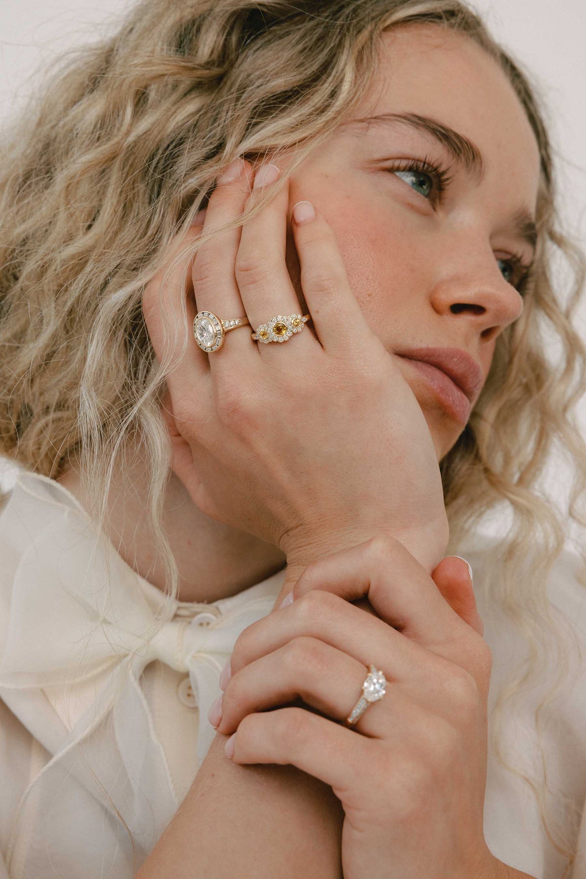 A close up photo of a woman wearing multiple rings