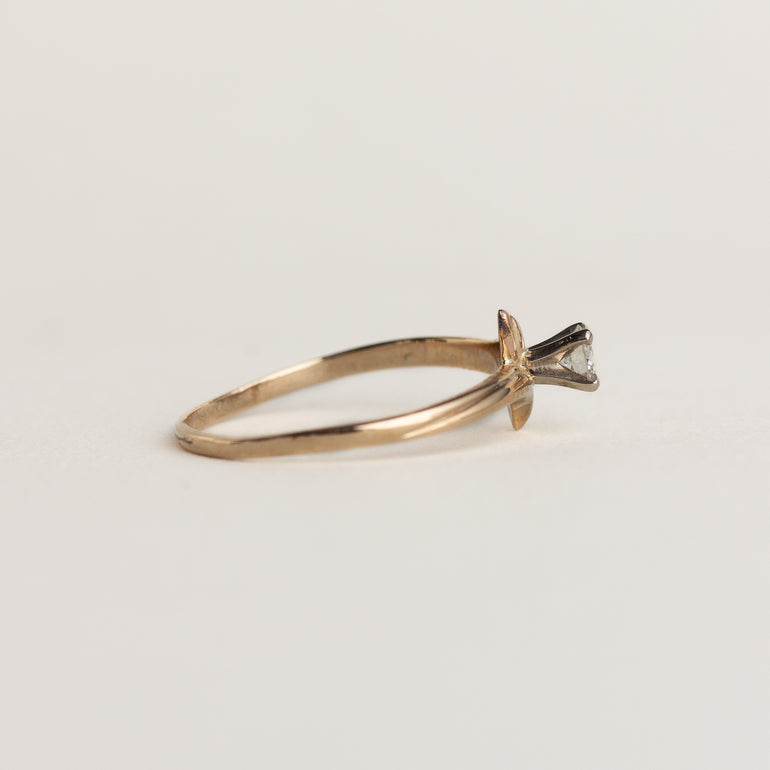 Gold ring with a diamond on a light gray background
