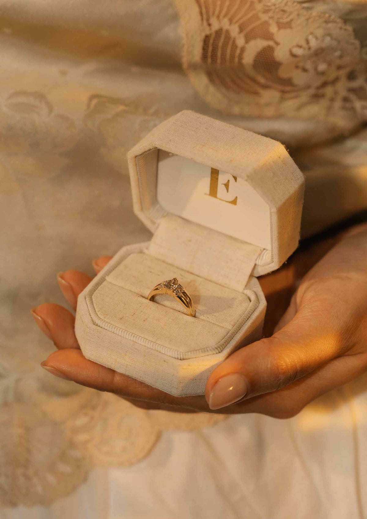 A vintage ring with champagne diamond in a ring box on a golden textured background