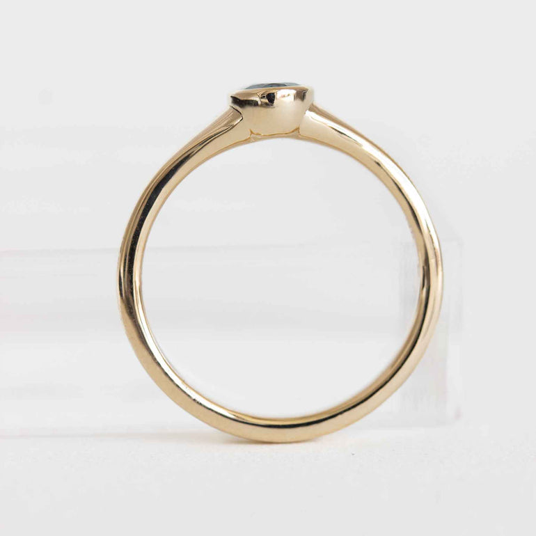 Gold ring with a small gemstone on a white background