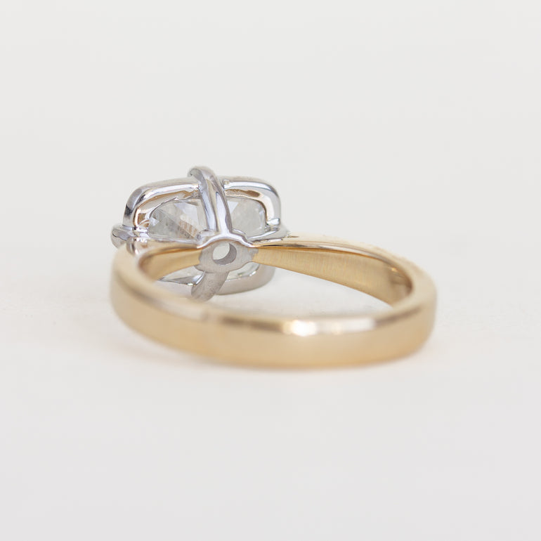Two rings, one gold and one silver, on a light gray background