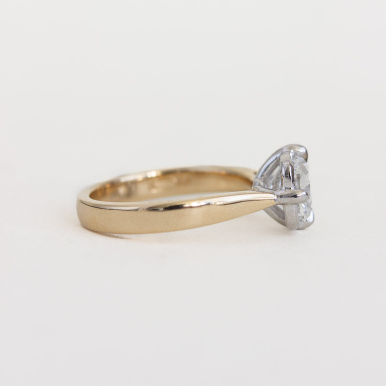 Gold ring with a diamond on a light gray background