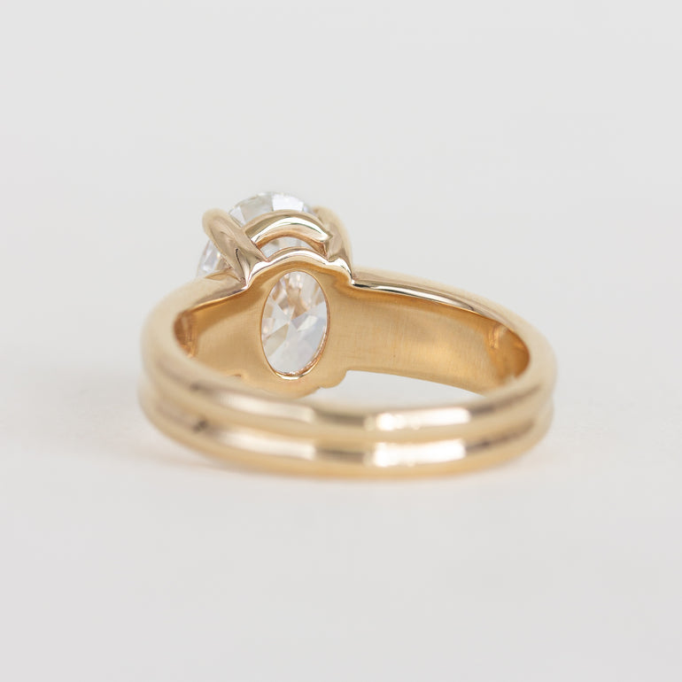 Gold ring with a diamond on a light gray background