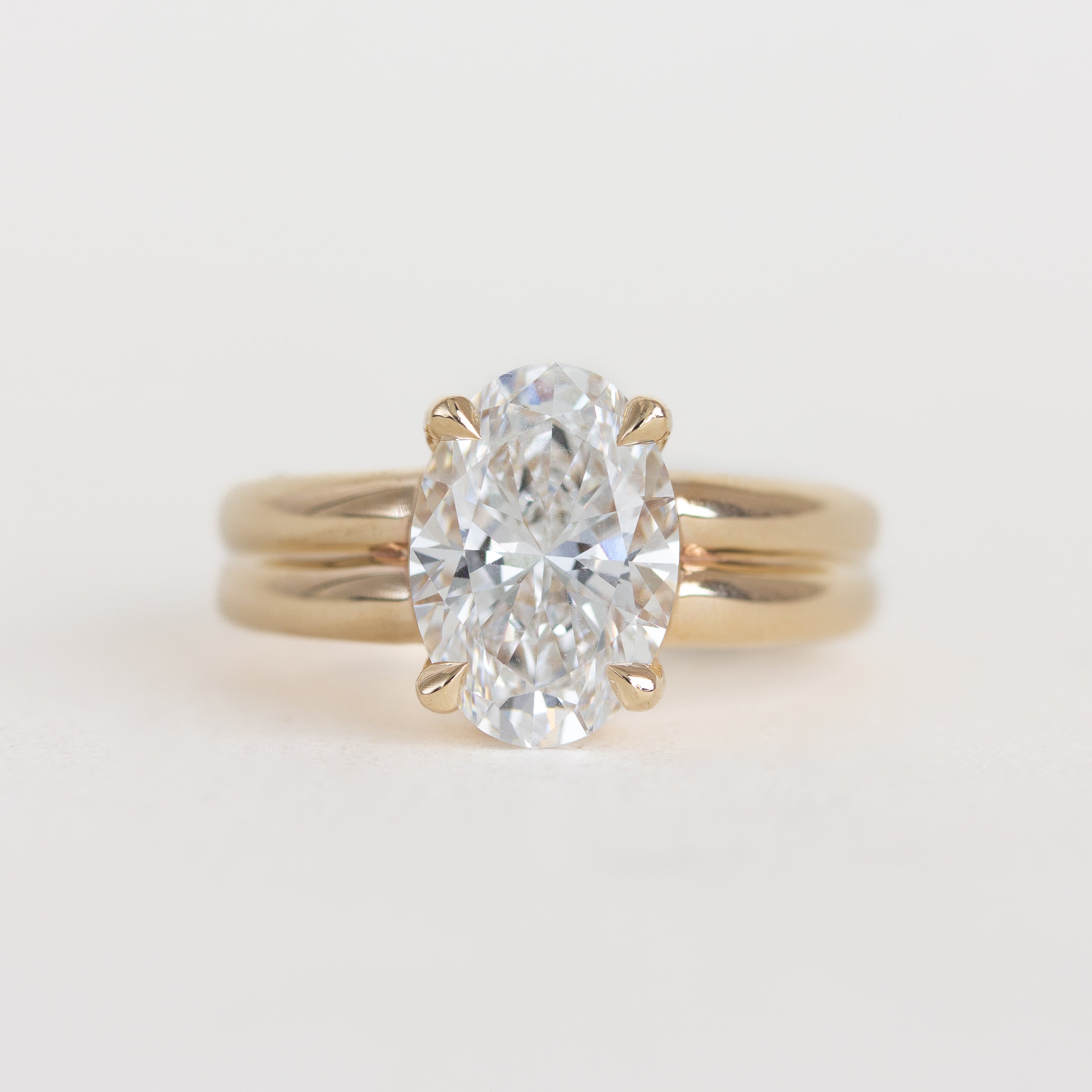 Gold ring with a large diamond on a light gray background