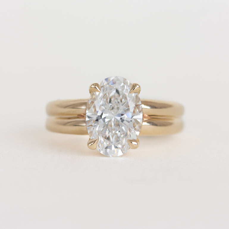 Gold ring with a large diamond on a light gray background