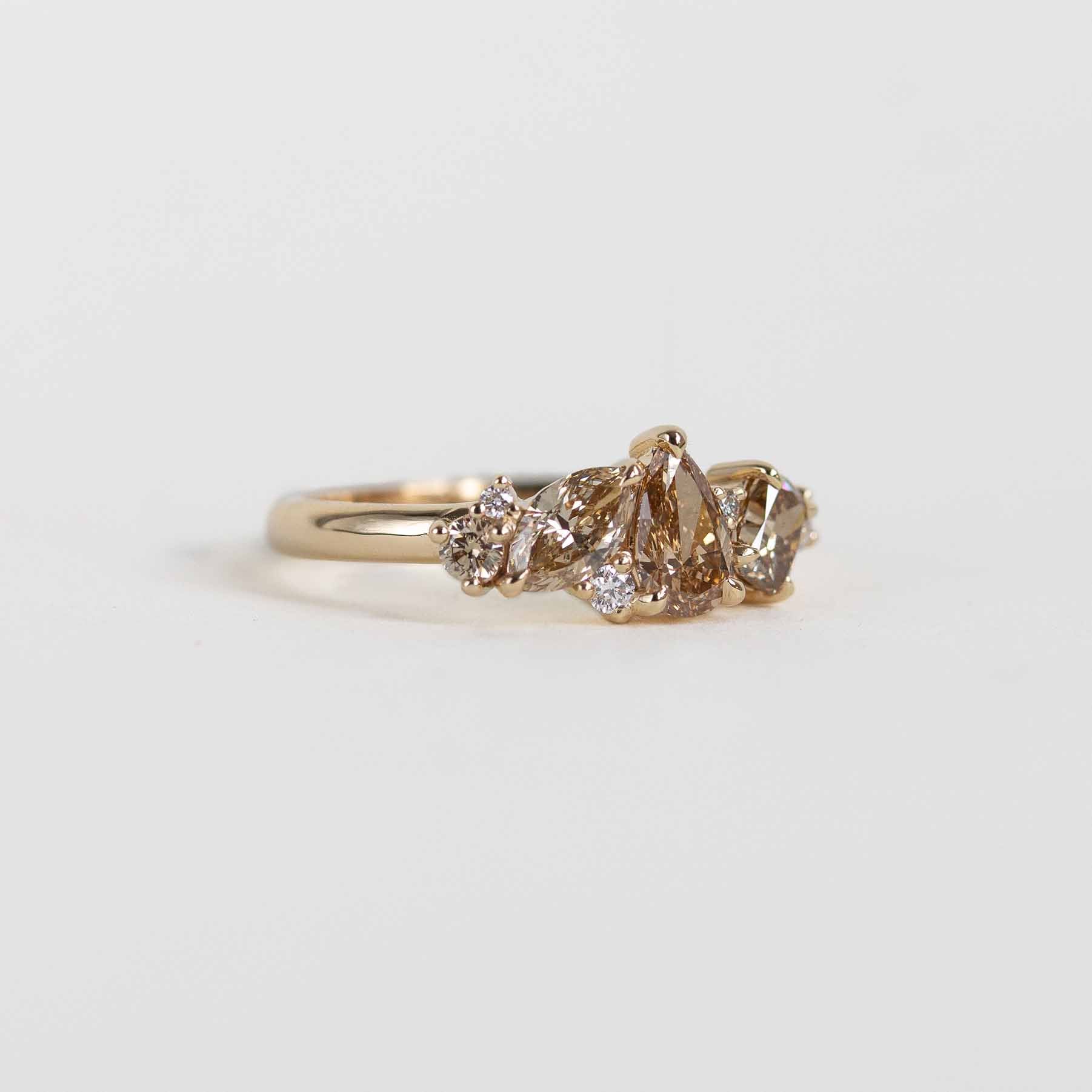 A gold ring cluster ring with champagne and clear natural diamonds, shown on a plain white background.