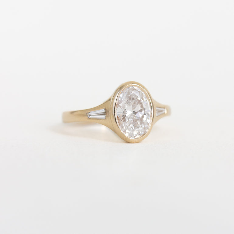 Oval Bezel Set Diamond Ring with Baguette Side Stones