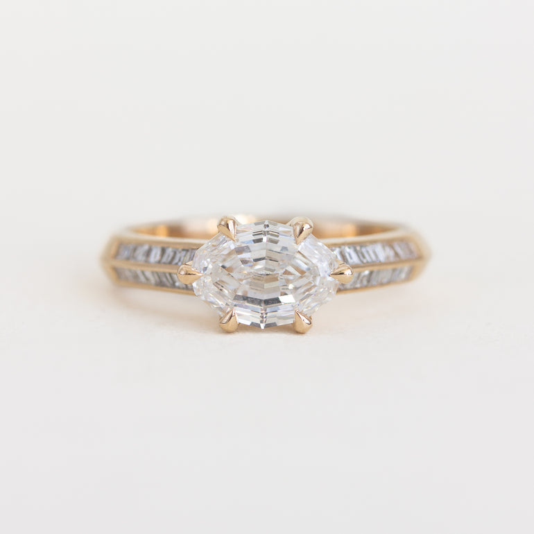 Gold ring with a diamond on a light gray background