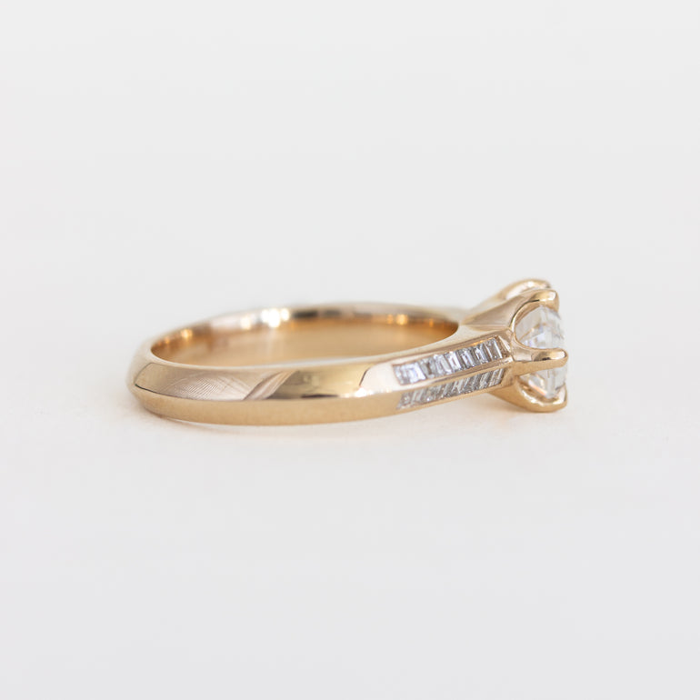 Gold ring with a diamond on a light gray background