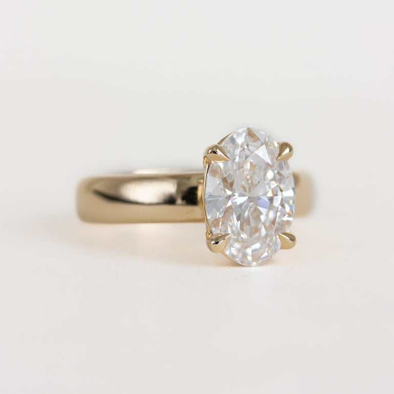 Gold ring with a large diamond on a light gray background