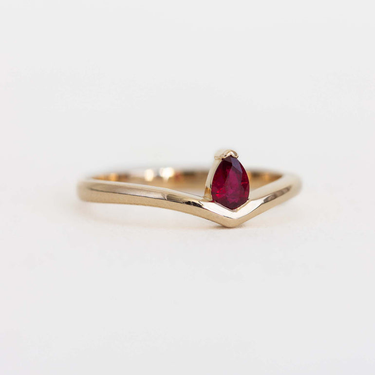 Angled photo of 14K yellow gold ring with pear shaped ruby
