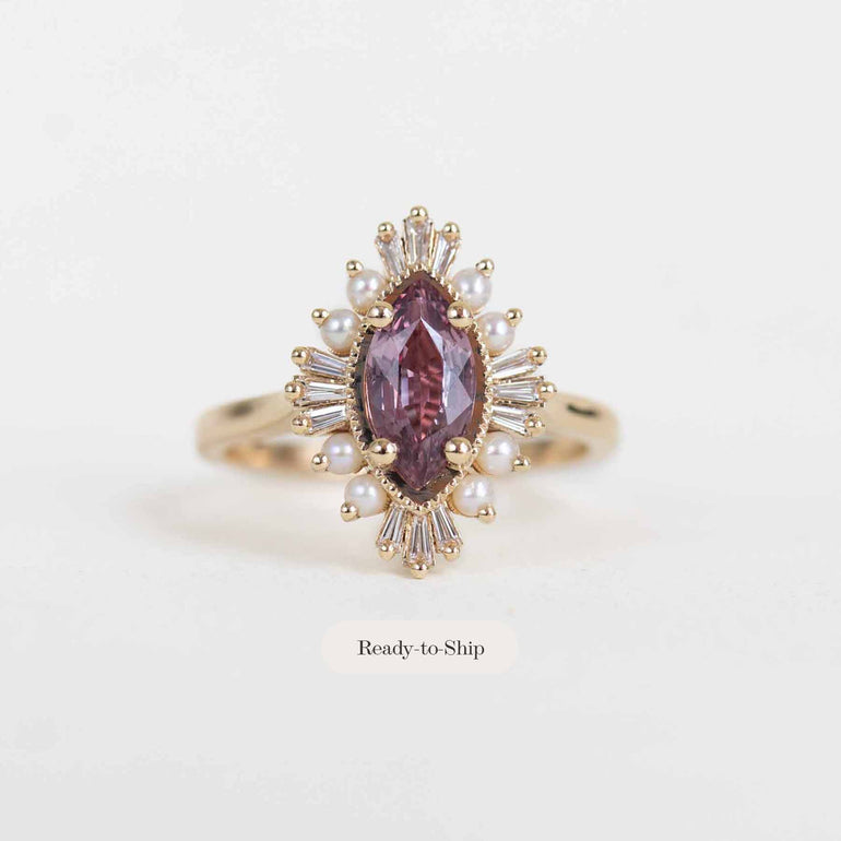 A gold ring featuring a marquise-cut pinkish-purple center stone surrounded by small white pearls and clear crystals, shown on a plain light background with a 'Ready-to-Ship' label below.