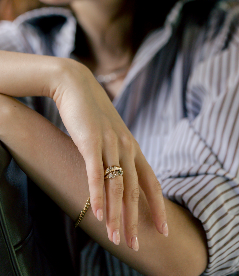 Close-up of a hand with gold rings on a blurred background