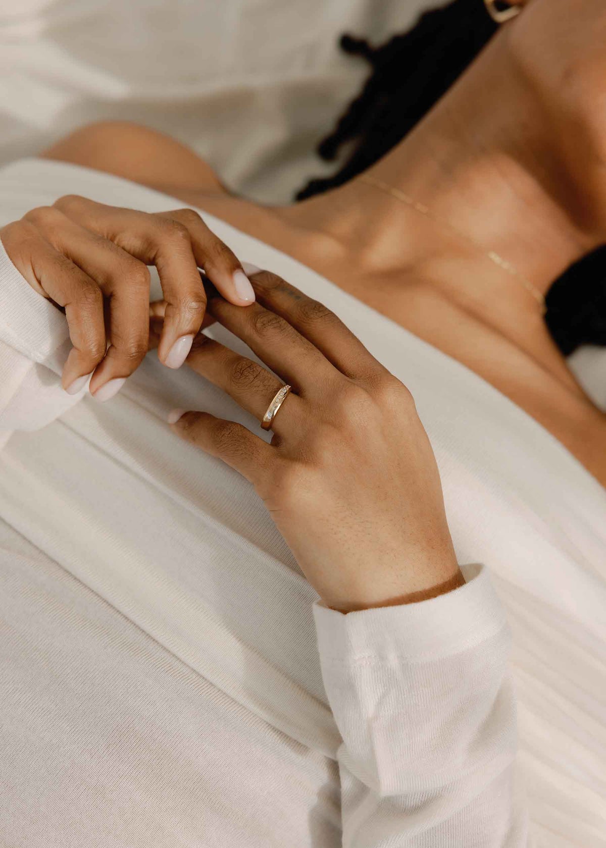 A close up of a woman's hands wearing a wedding band