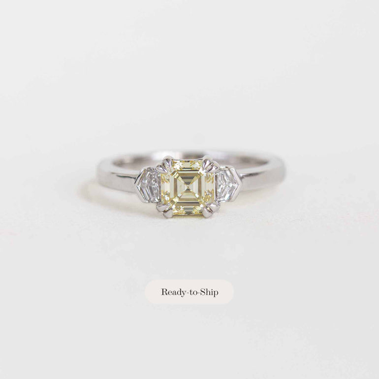 A yellow emerald-cut diamond engagement ring in a silver-toned setting with accent diamonds, shown on a light gray background with a 'Ready-to-Ship' label below.