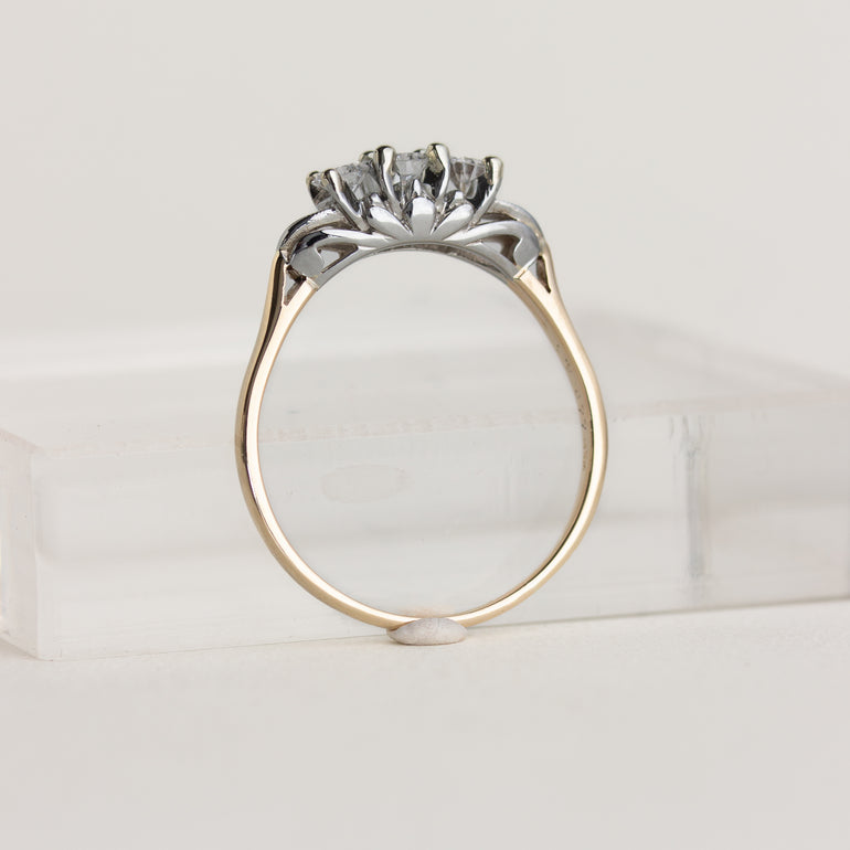 Gold and silver ring with a diamond on a white background