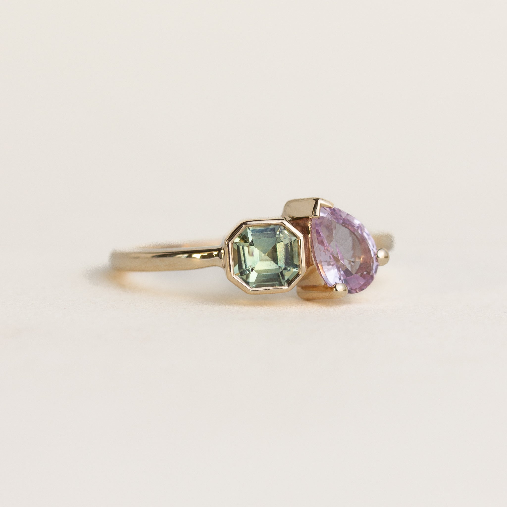 Toi et Moi 14k gold ring with green asscher and lilac pear sapphires