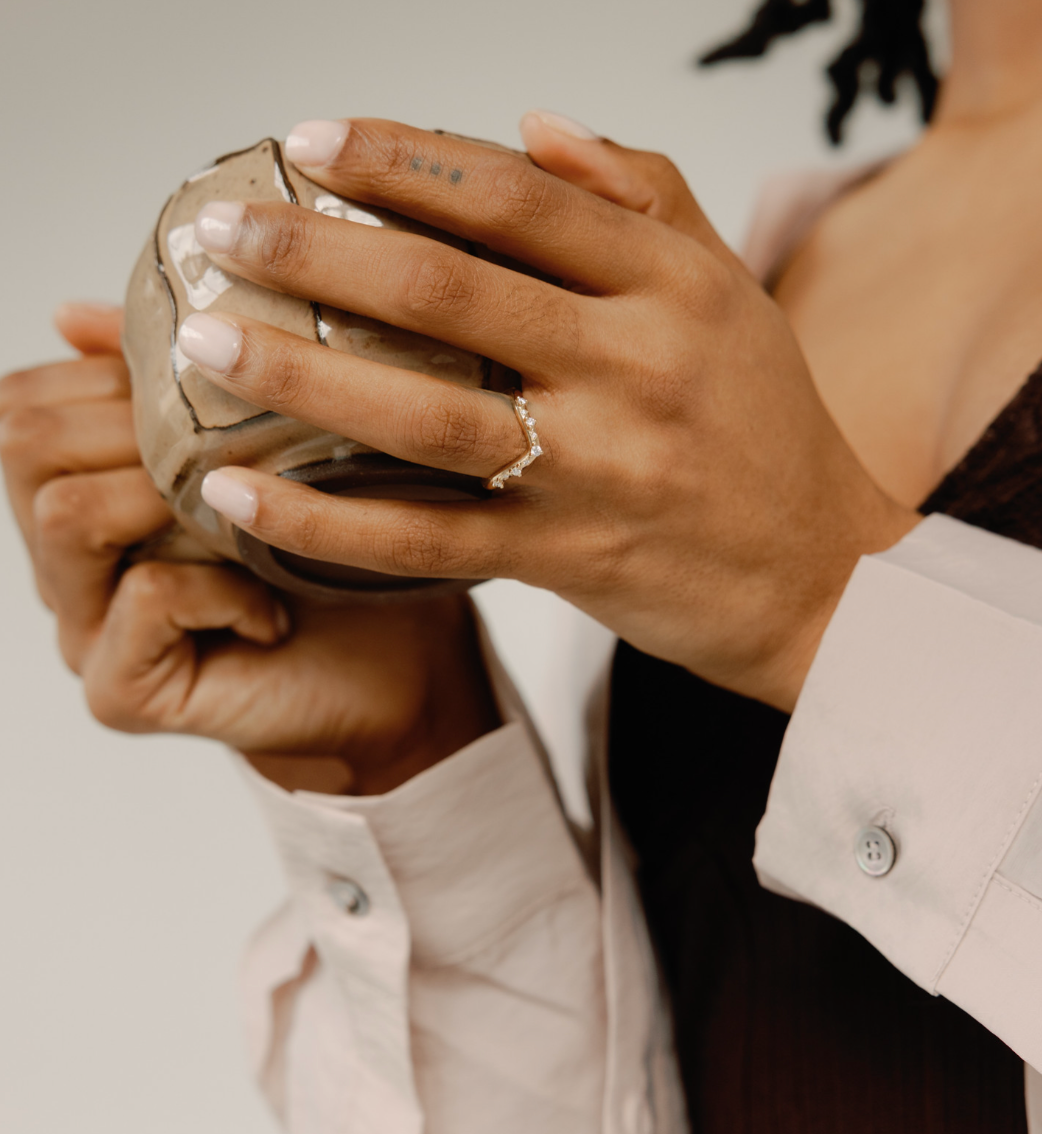 woman holding cup wearing wedding ring