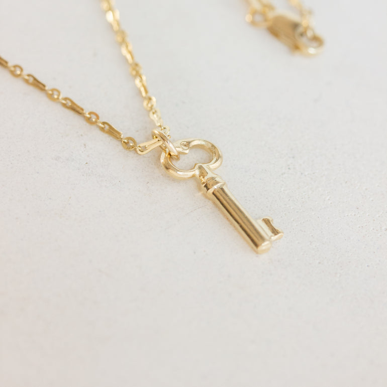 gold key charm on chain