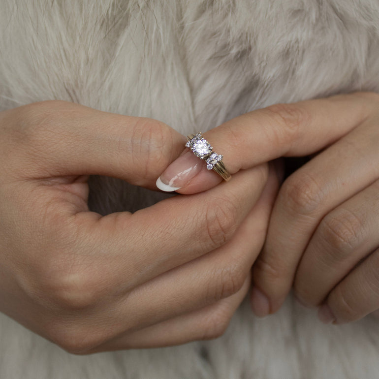 Close-up of a hand wearing a diamond ring on a fur surface