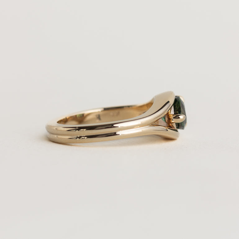 14K gold Lola ring with an east-west pear shaped, medium-green sapphire