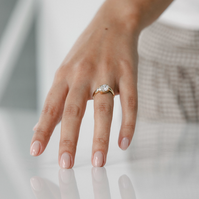 Oval lab grown diamond engagement ring with curved 14k yellow gold band