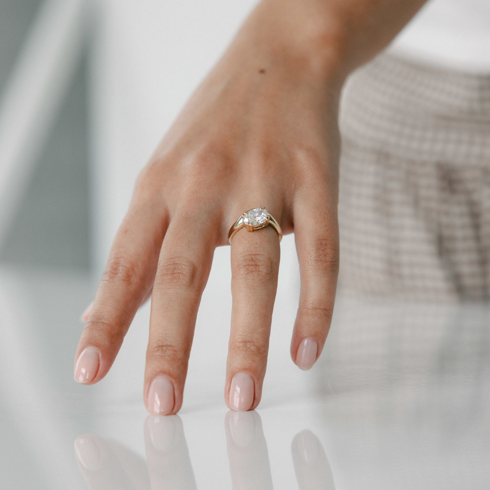 Oval lab grown diamond engagement ring with curved 14k yellow gold band