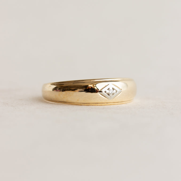 Gold ring with a diamond cutout on a light gray background