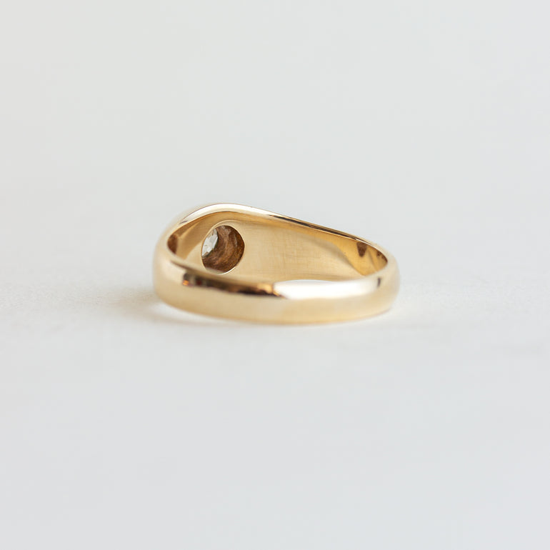 Gold ring with a heart-shaped cutout on a light gray background