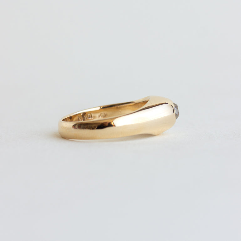 Gold ring with a diamond on a light gray background