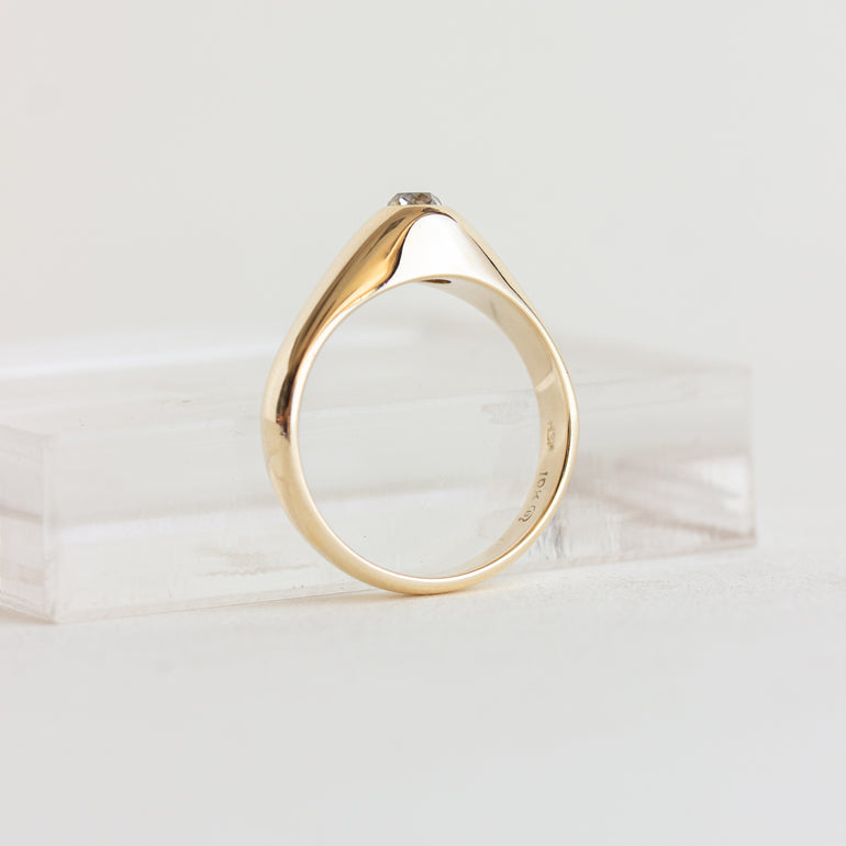 Gold ring with a diamond on a light background