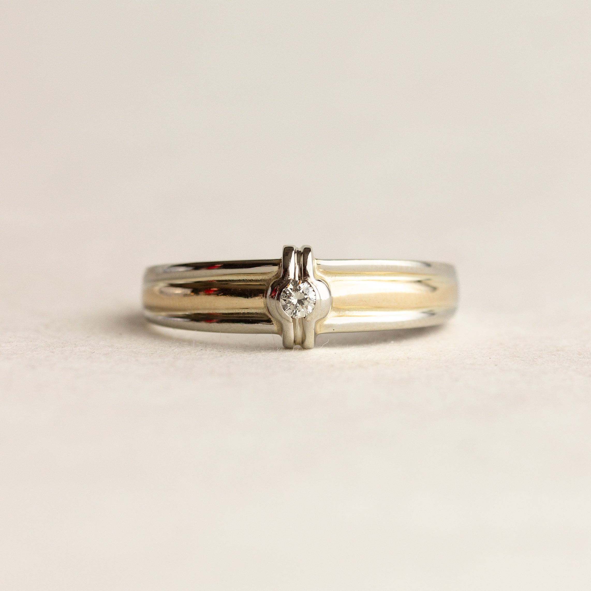 Two gold rings on a beige background