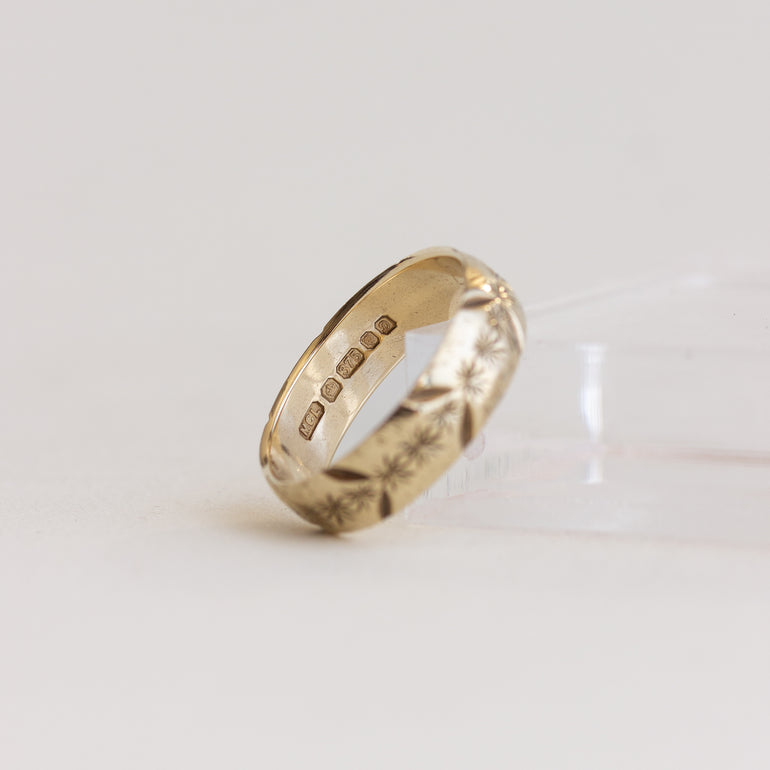 Gold ring with engraved text on a light gray background