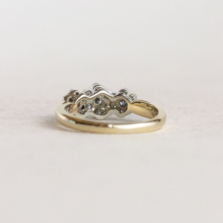Gold ring with diamonds on a light gray background