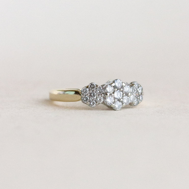 Diamond ring with a gold band on a light gray background
